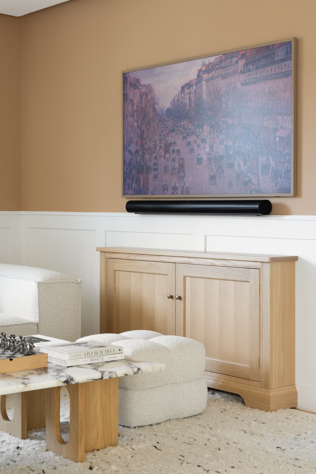 Lake Geneva House — oak console beneath a framed artwork with panelled walls and a bouclé ottoman