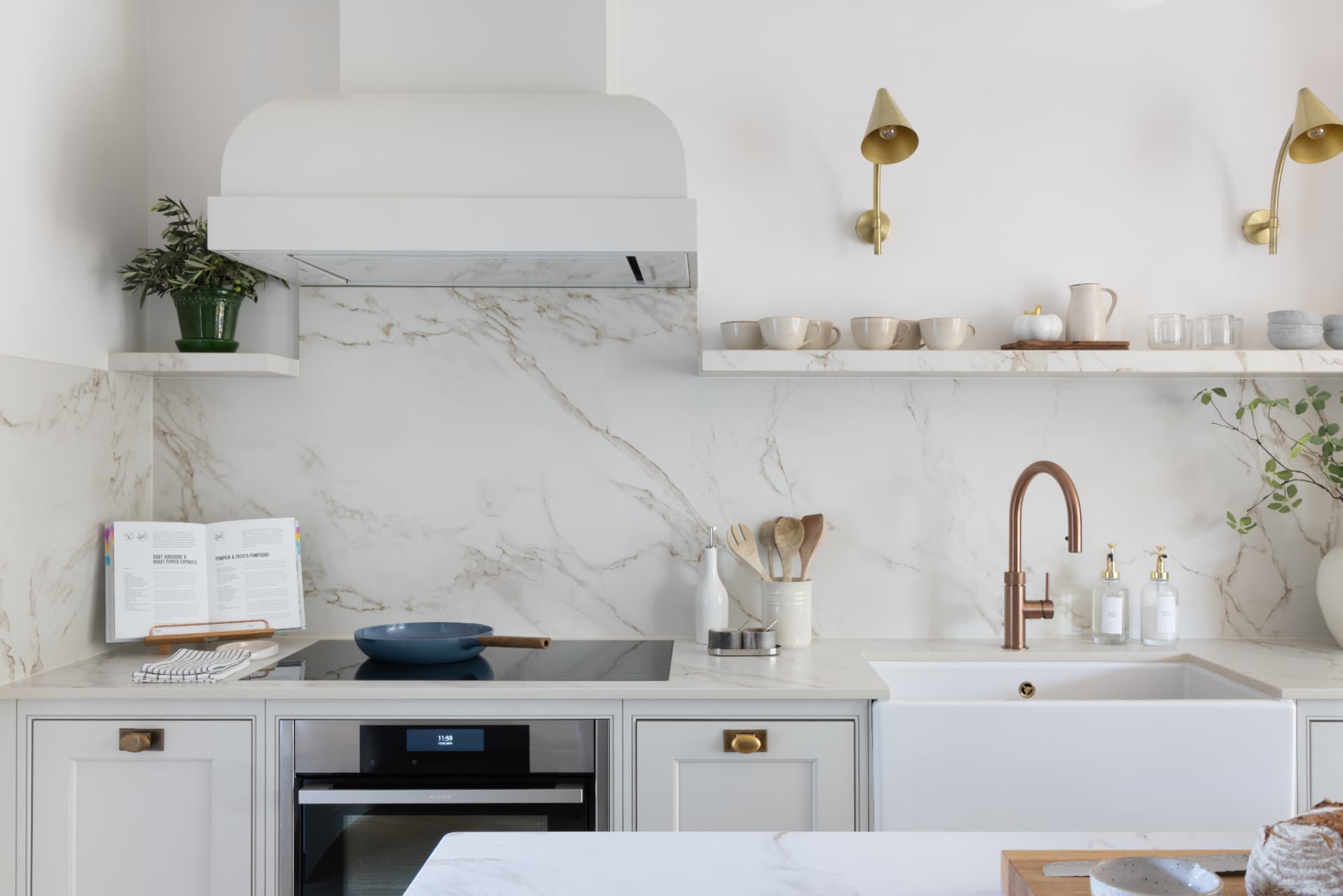 Lake Geneva House — range wall with marble backsplash, brass wall lights and a copper tap